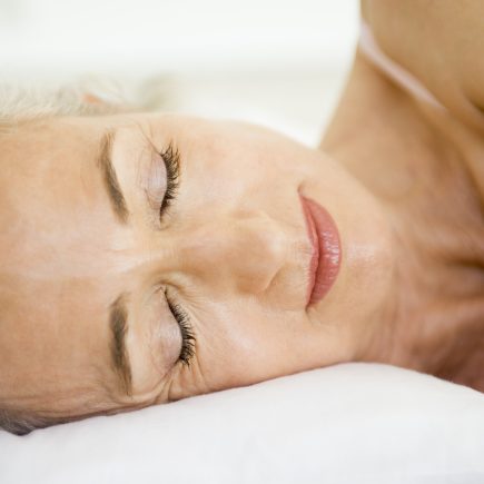 Retired man or woman lying awake in bed during early morning, eyes open in quiet reflection, capturing the emotional weight of retirement sleep struggles