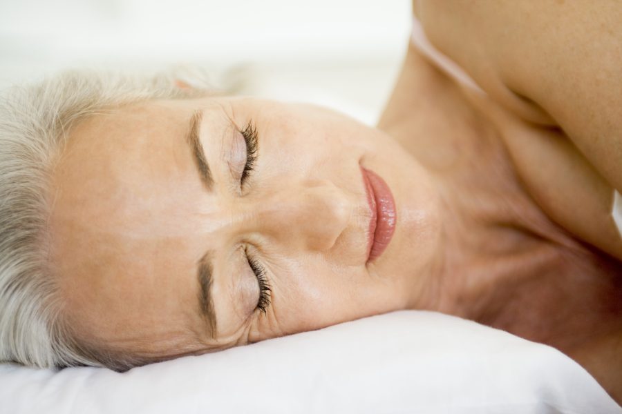 Retired man or woman lying awake in bed during early morning, eyes open in quiet reflection, capturing the emotional weight of retirement sleep struggles