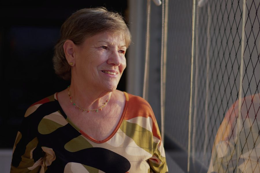 Confident retired woman smiling while walking outdoors, radiating energy and clarity