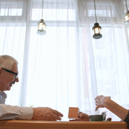 Retired couple smiling over coffee while having a meaningful conversation
