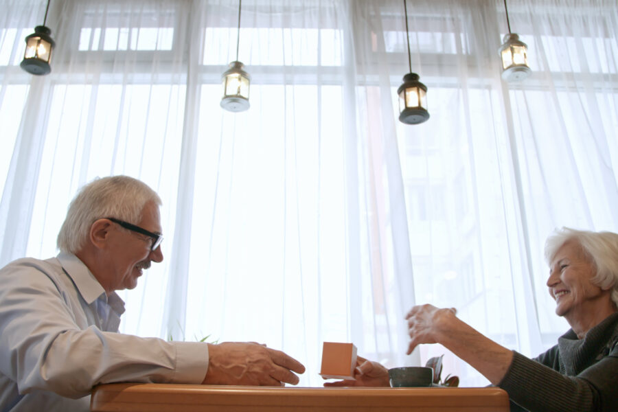 Retired couple smiling over coffee while having a meaningful conversation
