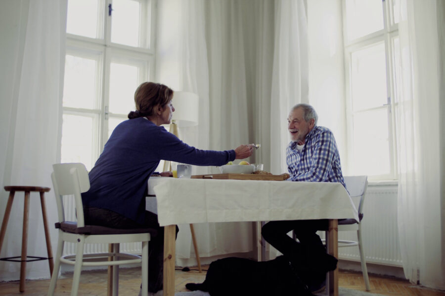 Retired couple enjoying a peaceful morning routine together in their kitchen.